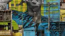 Aksi anak-anak saat bermain sepak bola di sebuah lapangan di Jardim Peri, Sao Paulo, Brasil, Minggu (20/5). Sebuah mural raksasa bergambar pemain sepak bola profesional Gabriel Jesus menghiasi permukiman mereka. (AP Photo/Andre Penner)