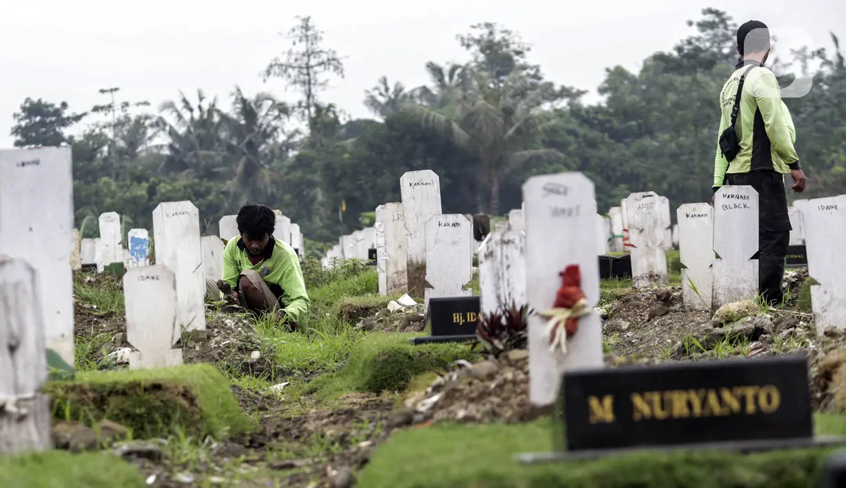 Sejumlah petugas membersihkan makam di Srengseng Sawah, Jakarta, Selasa (15/6/2021). Gubernur DKI Jakarta Anies Baswedan menjelaskan alasan angka kematian akibat COVID-19 di Jakarta relatif stabil dan terhitung sangat rendah. (Liputan6.com/Johan Tallo)
