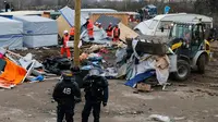 Alat berat saat merobohkan kamp pengungsian di lahan kumuh yang dijuluki "Jungle" di Calais, Prancis (1/3). Kamp ini berpenghuni sekitar 3.000 pengungsi dan pencari suaka. (REUTERS/Pascal Rossignol)
