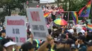 Seorang warga membentangkan poster anti-gay ditengah kerumunan peserta parade 'Gay Pride' di Seoul, Korea Selatan (15/7). Kelompok anti-gay ini mendesak kaum homoseksual untuk kembali mengikuti ajaran Yesus Kristus. (AP Photo / Ahn Young-joon)