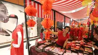 Penjaga stand pameran merapikan barang dagangannya sambut perayaan Imlek di Lippo Mall Puri, Jakarta, Minggu (4/2). Bazar yang digelar selama bulan Februari ini menyediakan pernak-pernik Imlek, makanan dan baju. (Liputan6.com/Fery Pradolo)