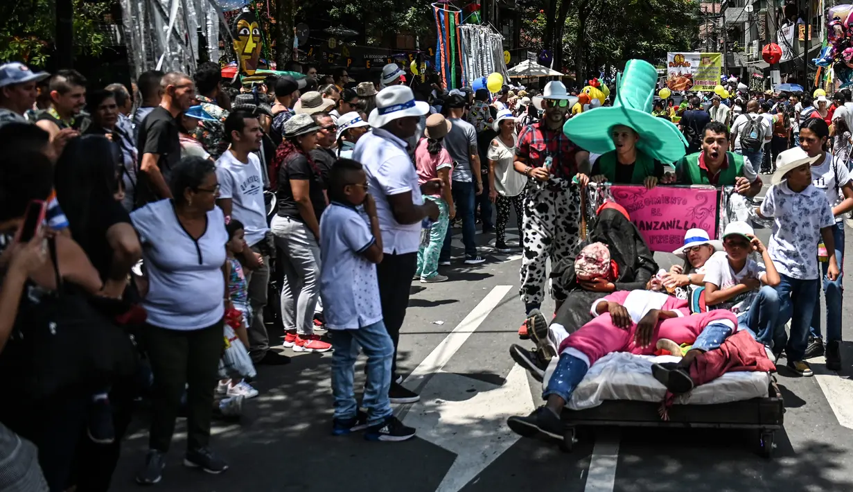 Warga berbaring di ranjang saat berparade merayakan Hari Malas Sedunia di Itagui, dekat Medellin, Kolombia, Minggu (18/8/2019). Acara ini pertama kali digelar oleh Carlos Mario Montoya agar Itagui tidak hanya merayakan hiruk-pikuk bisnis, tetapi juga untuk menikmati hidup. (JOAQUIN SARMIENTO/AFP)
