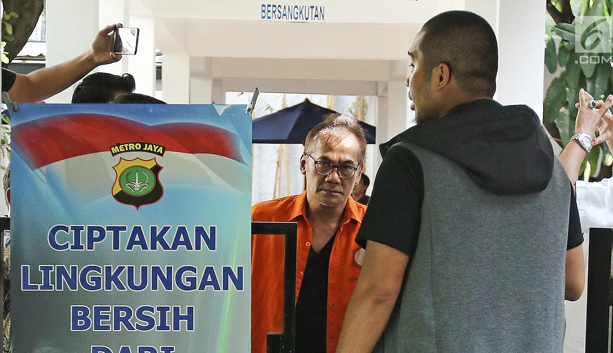 Tersangka Tio Pakusadewo digiring polisi jelang jumpa pers terkait kepemilikan narkoba jenis sabu di Dit Narkoba Polda Metro Jaya, Jakarta, Jumat (22/12). Polisi menangkap Tio Pakusadewo pada 20 Desember 2017. (Liputan6.com/Herman Zakharia)