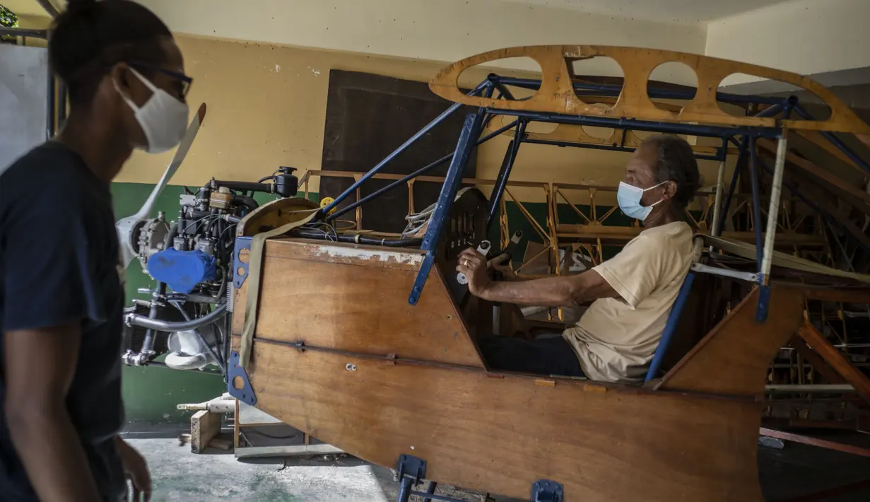 Adolfo Rivera (70) berpose di dalam pesawat yang dia buat di garasi gedung apartemennya di Havana, Kuba, 19 Februari 2021. Rivera yang merupakan insinyur mekanik dan profesor universitas tersebut menciptakan pesawat terbang kayu, dua tempat duduk selama delapan tahun. (AP Photo/Ramon Espinosa)