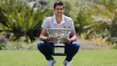 Petenis Serbia, Novak Djokovic berpose dengan piala juara tunggal putra Australia Terbuka 2020 saat sesi pemotretan di Royal Botanic Gardens Victoria, Melbourne, Australia, Senin (3/2/2020). Bagi Novak Djokovic, ini merupakan gelar Australia Terbuka kedelapan. (AP Photo/Dita Alangkara)