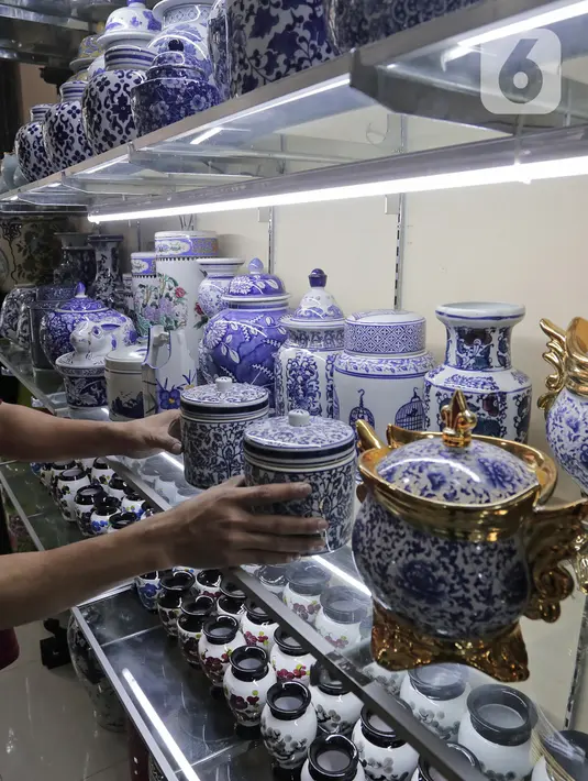Pembeli melihat produk keramik yang dijual di kios kerajinan keramik kawasan Tanjung Priuk, Jakarta Utara, Kamis (23/9/2021). Pedagang mengaku pasokan keramik menurun hingga 70 persen seiring dangan pembatasan produksi pabrik akibat perpanjangan PPKM. (Liputan6.com/Herman Zakharia)