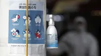 Botol cairan pembersih tangan disediakan di sisi jalan untuk warga di sebelah pemberitahuan tentang tindakan pencegahan COVID-19 di depan pasar di Seoul, Korea Selatan (26/2/2020). Cairan pembersih berbasis alkohol bisa membunuh virus yang kemungkinan berada di tangan. (AP Photo/Lee Jin-man)
