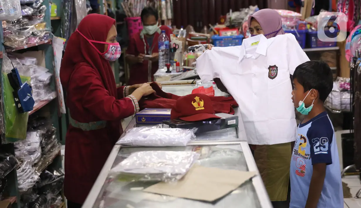 Pedagang melayani pembeli seragam sekolah baru di salah satu toko di Tangerang, Banten, Selasa (2/6/2020). Menjelang tahun ajaran baru, sejumlah pedagang di tempat tersebut mengeluh karena omzet penjualan seragam sekolah menurun drastis akibat pandemi COVID-19. (Liputan6.com/Angga Yuniar)