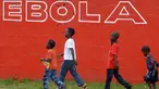 Sejumlah anak berjalan melewati dinding yang bertuliskan 'Ebola' di Monrovia, Liberia, 31 Agustus 2014. Liberia melarang para awak kapal untuk berlabuh di negara-negara yang rentan epidemi Ebola. (AFP PHOTO/DOMINIQUE FAGET)