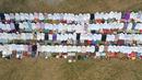 Foto dari udara memperlihatkan umat muslim melaksanakan salat minta hujan (Istisqa) saat kabut asap menyelimuti kota Pekanbaru, di Riau, Jumat (13/9/2019). Ini dilakukan berharap agar Allah menurunkan hujan di Pekanbaru yang terus diselimuti asap dengan kualitas udara yang memburuk. (ADEK BERRY/AFP)