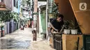 Warga makan di atas pagar rumah saat banjir merendam permukiman di Kebon Pala, Jakarta, Senin (8/2/2021). Hujan deras yang mengguyur Ibu Kota dan wilayah Bogor menyebabkan permukiman di Kebon Pala terendam banjir sejak Minggu (7/2/2021) sore. (merdeka.com/Iqbal S. Nugroho)
