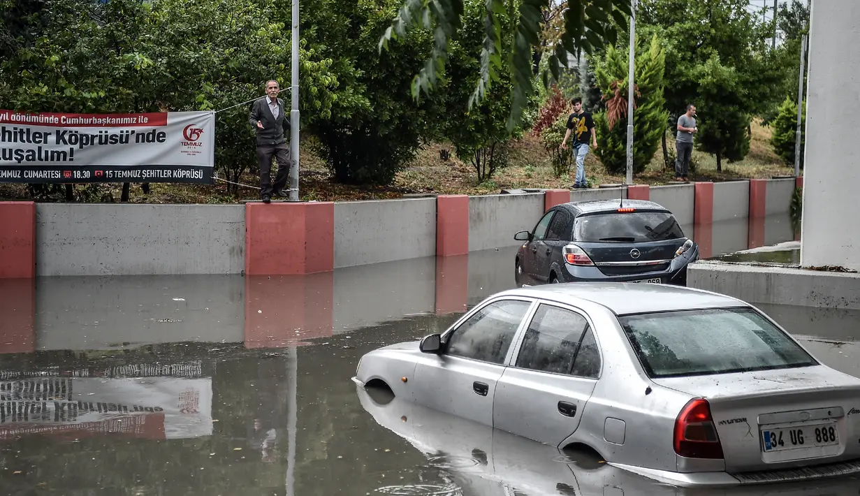 Sejumlah mobil mulai tenggelam akibat tingginya debit air banjir di stasiun metro Bayrampasa, kota Istanbul, Turki, Selasa (18/7). Sejumlah besar wilayah kota terendam banjir cukup parah akibat diguyur hujan lebat selama 12 jam. (OZAN KOSE / AFP)