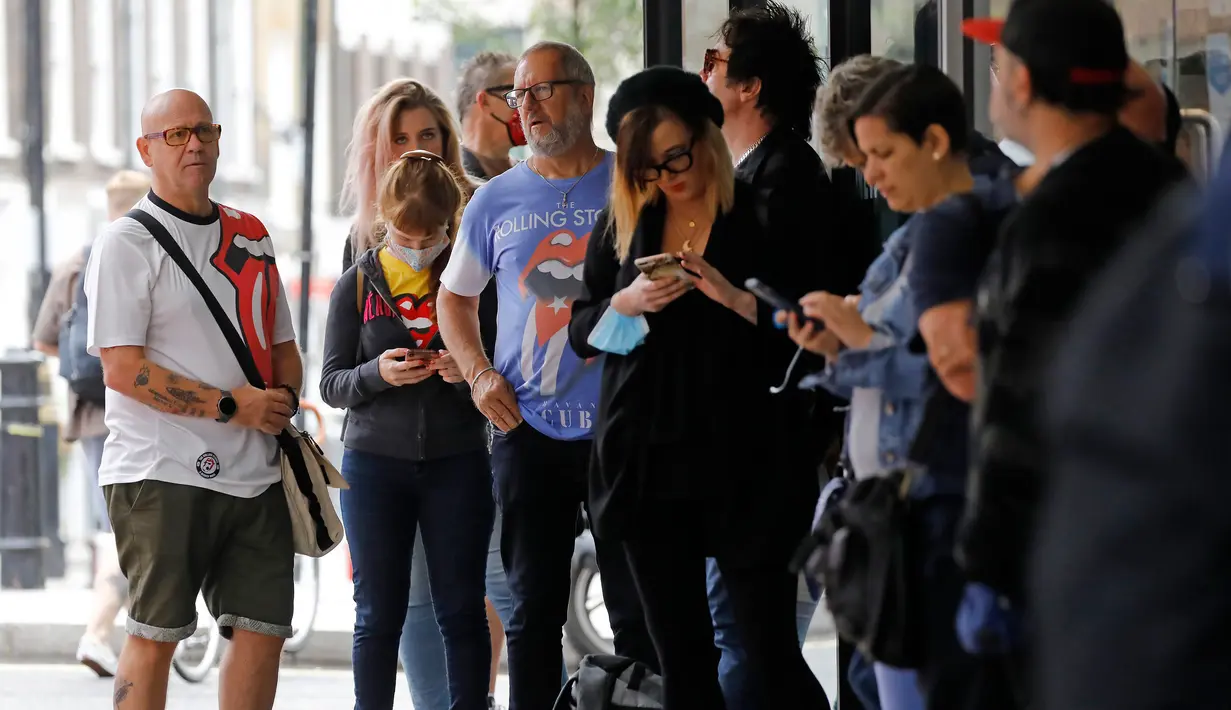 Orang-orang mengantre untuk memasuki toko andalan The Rolling Stones yang baru sebelum hari pertama pembukaannya di London, Rabu (9/9/2020). Rolling Stones membuka membuka toko pertamanya di 9 Carnaby Street. (Tolga Akmen / AFP)