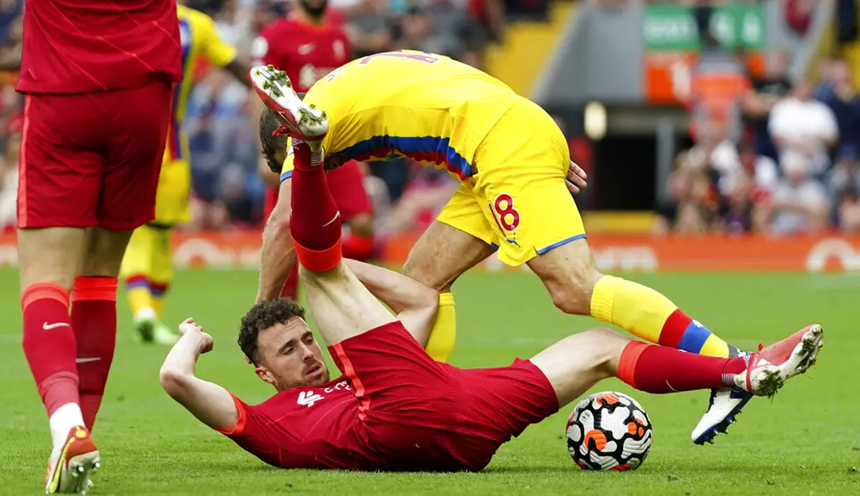 Pemain Liverpool Diogo Jota (bawah) berebut bola dengan pemain Crystal Palace James McArthur pada pertandingan Liga Inggris di Stadion Anfield, Liverpool, Inggris, Sabtu (18/9/2021). Liverpool menang telak 3-0. (AP Photo/Jon Super)