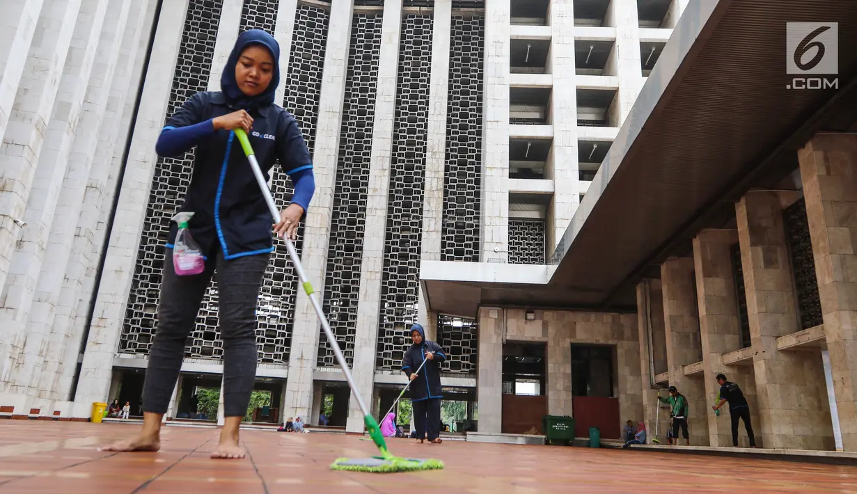 Pekerja wanita membersihkan lantai dalam rangka program Ramadan Tanpa Batas di Masjid Istiqlal, Jakarta, Kamis (15/06). Sebanyak 150 mitra Go-Clean dan driver Go-Jek bergotong royong membersihkan masjid. (Liputan6.com/Fery Pradolo)