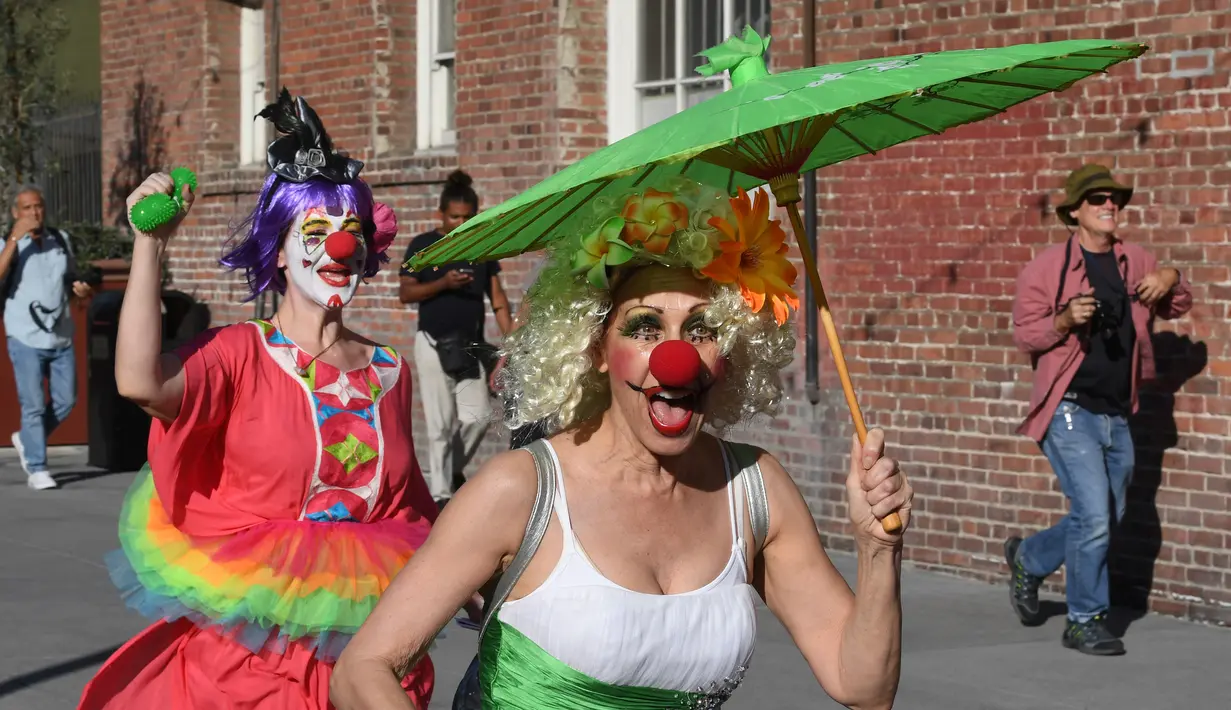 Para peserta berkostum badut berlarian selama acara 'Running of the Clowns' di Pasadena, California pada 21 Oktober 2018. Lari dikejar kawanan badut ini merupakan parodi yang mengolok-olok lomba dikejar banteng di Pamplona, Spanyol. (Mark RALSTON/AFP)