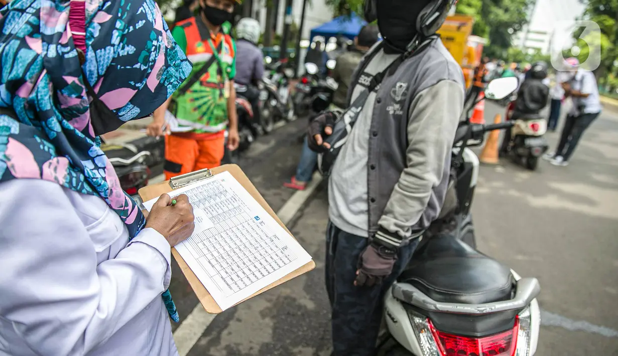 Petugas mendata pengendara saat uji emisi gas buang kendaraan bermotor di Jakarta, Rabu (6/1/2021). Pengecekan yang diselenggarakan Dinas Perhubungan dan Kepolisian tersebut bertujuan untuk mengurangi polusi udara dari emisi gas buang kotor. (Liputan6.com/Faizal Fanani)