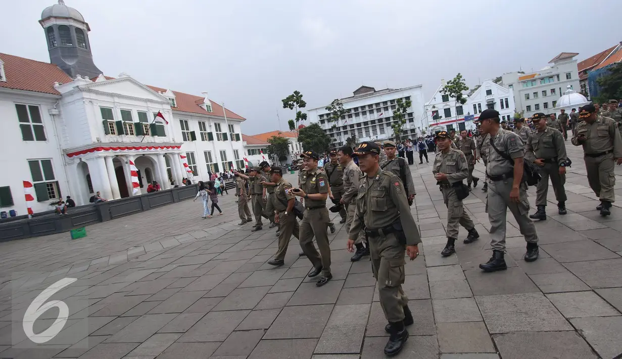 Petugas gabungan menertibkan PKL dan parkir liar di kawasan wisata Kota Tua, Jakarta, Rabu (24/8). Penertiban dilakukan guna membenahi PKL dan parkir liar yang kerap menimbulkan kesewrautan di lokasi tersebut. (Liputan6.com/Immanuel Antonius)