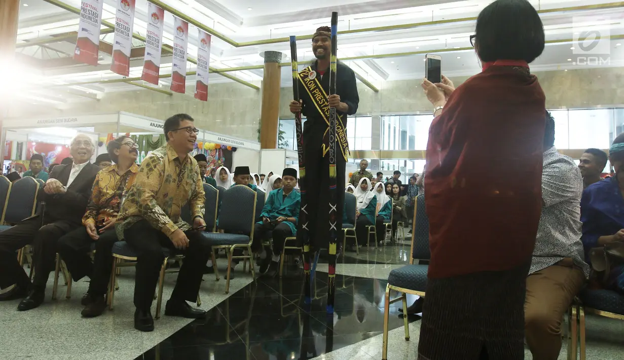 Pendiri Komunitas Tanoker, Suporahardjo mencoba egrang saat menjadi pembicara dalam Dialog Sambung Rasa mengenai Pancasila dan Pengembangan Ekonomi Rakyat pada Festival Prestasi Indonesia di Jakarta, Selasa (22/8). (Liputan6.com/Herman Zakharia)