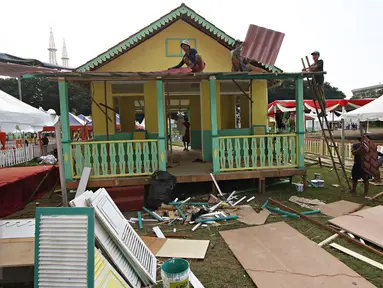 Pekerja menyelesaikan pembuatan rumah adat betawi jelang pelaksanaan Festival Lebaran Betawi IX di Lapangan Banteng, Jakarta, Kamis (11/8). Festival Lebaran Betawi IX tersebut akan digelar pada 12-13 Agustus 2016. (Liputan6.com/Immanuel Antonius)