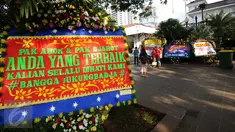 Warga berfoto di depan karangan bunga untuk Gubernur DKI Jakarta Basuki Tjahaja Purnama dan Wagub Djarot Sjaiful Hidayat di halaman Balai Kota Jakarta, Selasa (25/4). Karangan bunga ini berisi pernyataan dukungan. (Liputan6.com/Helmi Fithriansyah) 