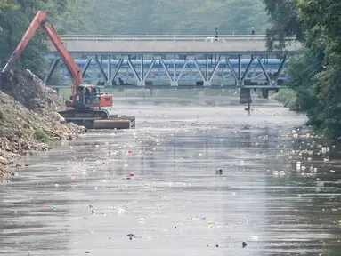  Warga menonton alat berat mengeruk kali Ciliwung di jalur Manggarai, Jakarta, Selasa (12/7). Cegah pendangkalan, Dinas Tata Air DKI Jakarta keruk kali Ciliwung. (Liputan6.com/Yoppy Renato)