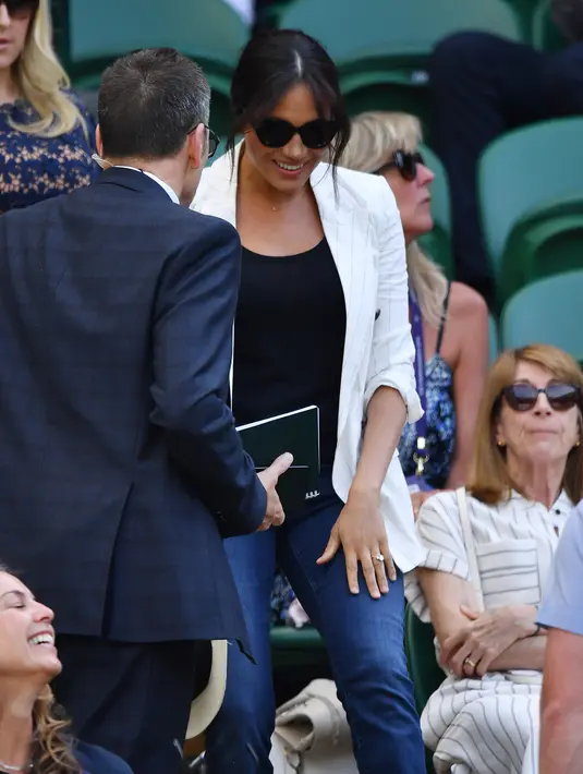 Meghan Markle tiba untuk menyaksikan petenis AS Serena Williams melawan Kaja Juvan dari Slovakia pada babak kedua Wimbledon di All England Lawn Tennis Club, London, Kamis (4/7/2019). Istri Pangeran Harry itu menjadi saksi Serena mengalahkan petenis Slovenia Kaja Juvan 2-6, 6-2, 6-4. (GLYN KIRK/AFP)