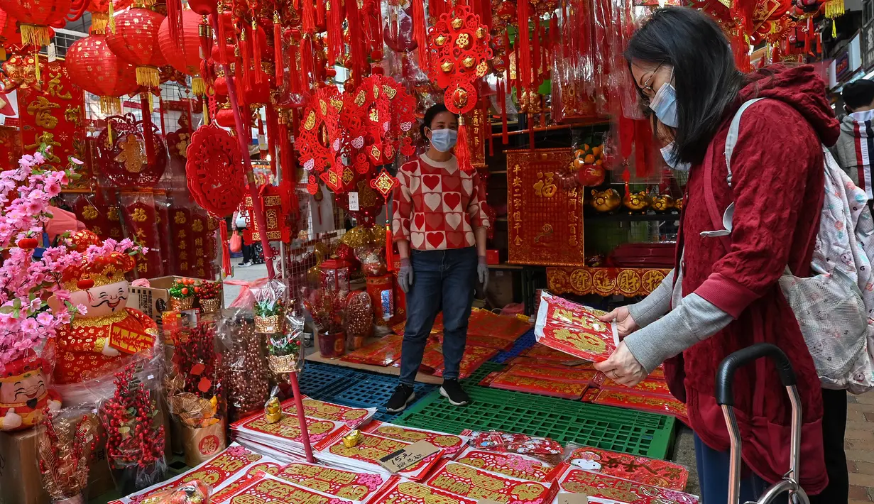 Seorang perempuan melihat dekorasi menjelang Tahun Baru Imlek di Hong Kong pada 26 Januari 2022. Tahun Baru Imlek untuk masyarakat Tionghoa atau China di seluruh dunia pada tahun ini akan jatuh pada tanggal 1 Februari 2022. (Peter PARKS / AFP)