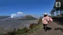 Warga melintas jalan dengan latar belakang kaldera Gunung Bromo di kawasan Cemoro Lawang, Probolinggo, Jawa Timur, Kamis (9/9/2021).  Kawasan kaldera Gunung Bromo dan hamparan pasir yang masih ditutup karena pemberlakuan PPKM Darurat. (merdeka.com/Arie Basuki)
