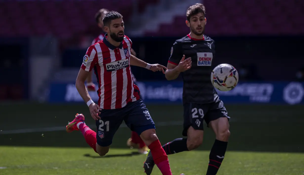 Gelandang Atletico Madrid, Yannick Carrasco (kiri) mengejar bola saat menghadapi Eibar dalam laga lanjutan Liga Spanyol 2020/2021 pekan ke-31 di Wanda Metropolitano Stadium, Madrid, Minggu (18/4/2021). Atletico menang 5-0 atas Eibar. (AP/Bernat Armangue)
