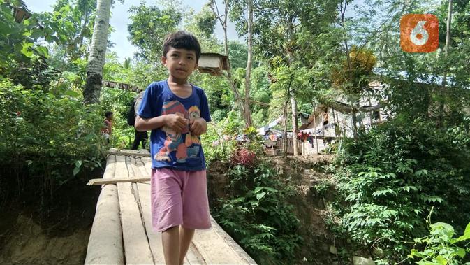 seorang bocah melintas di jembatan kayu Desa Lampo, Donggala yang menjadi salah satu akses menuju hutan. (Foto: Liputan6.com/ Heri Susanto).
