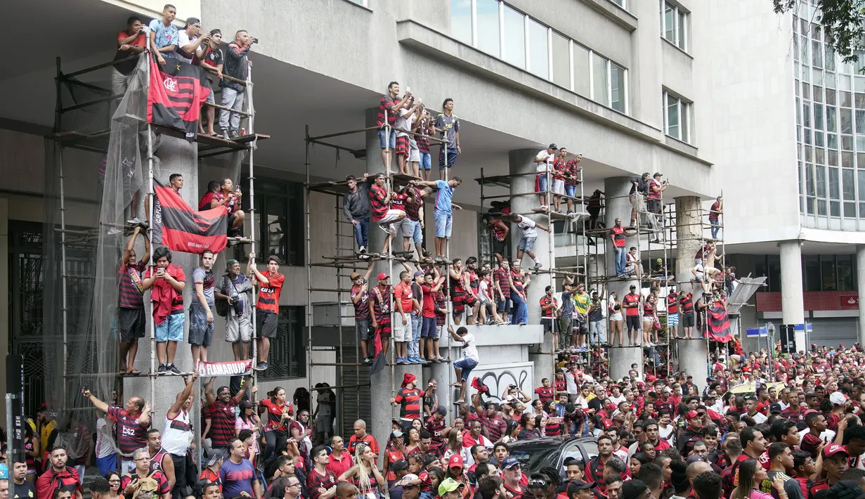 Suporter Flamengo menyaksikan parade kemenangan timnya saat kedatangan mereka di Rio de Janeiro, Brasil (24/11/2019). Flamengo berhasil mengalahkan River Plate 2-1 pada final Copa Libertadores di Lima untuk memenangkan Gelar keduanya. (AP Photo/Ricardo Borges)