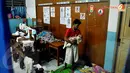 Seorang pria menggendong bayinya. Ia menjadi salah satu warga yang memilih mengungsi ke gedung sekolah karena rumahnya terendam banjir (Liputan6.com/Andrian M Tunay).
