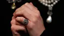 Foto pada 19 Oktober 2018, model mengenakan cincin monogram mendiang Ratu Prancis, Marie Antoinette di Sotheby, London. Cincin itu memuat seikat rambut Ratu Marie dan termasuk perhiasan yang dilelang di Jenewa pada 14 November 2018. (AP/Frank Augstein)