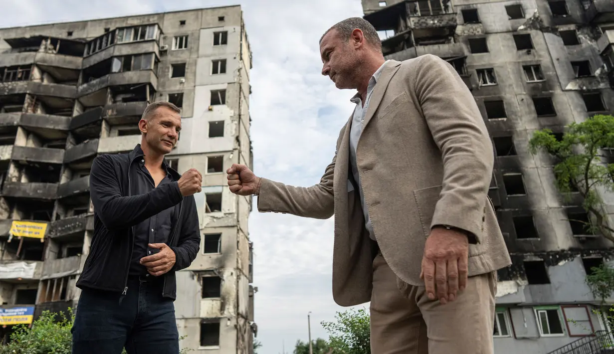 Mantan striker dan pelatih tim nasional sepak bola Ukraina Andriy Shevchenko (kiri) bersalaman dengan aktor Amerika Serikat Liev Schreiber di depan sebuah rumah yang telah dihancurkan oleh pemboman Rusia di Borodianka, dekat Kyiv, Ukraina, 15 Agustus 2022. Andriy Shevchenko merupakan duta besar platform penggalangan dana UNITED24 yang diluncurkan oleh Presiden Ukraina Volodymyr Zelenskyy sebagai tempat utama untuk mengumpulkan sumbangan amal untuk mendukung Ukraina. (AP Photo/Evgeniy Maloletka)