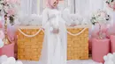 Aksen pita dan warna hijab dusty pink yang kontras, membuat tampilan Aurel terlihat memikat dan semakin glowing, jelang kelahirannya.