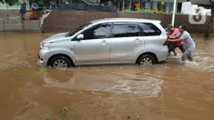 Sejumlah orang memindahkan mobil yang terendam banjir di kawasan Kemang, Jakarta, Kamis (2/1/2020). Banjir yang melanda Jakarta dan sekitarnya mengakibatkan banyak kendaraan terendam air. (Liputan6.com/Herman Zakharia)