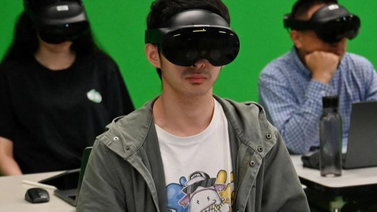 Di ruang kelas virtual, Albert Einsten mengajarkan teori permainan kepada para mahasiswa yang memakai headset virtual reality. Foto: AFP/PETER PARKS
