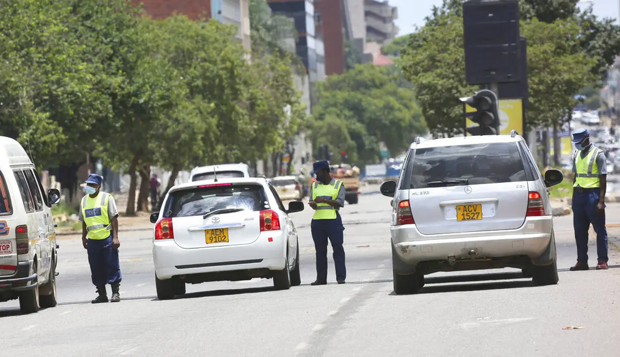 Polisi menghentikan pengendara di jalanan Harare, Zimbabwe, Selasa (5/1/2021). Menanggapi meningkatnya infeksi COVID-19, Zimbabwe telah memberlakukan kembali jam malam, melarang pertemuan publik, dan menangguhkan pembukaan sekolah tanpa batas waktu. (AP Photo/Tsvangirayi Mukwazhi)