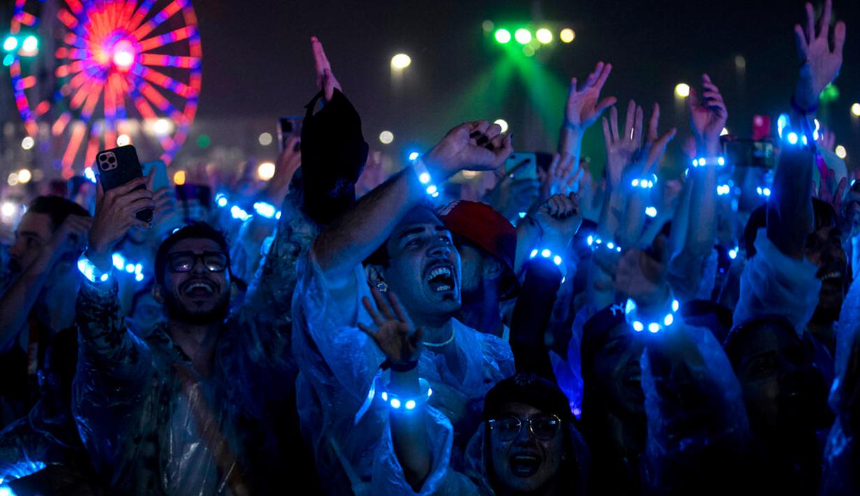 Penonton bersorak saat menonton penampilan band rock Inggris Coldplay pada festival musik Rock in Rio di Rio de Janeiro, Brasil, Minggu (11/9/2022). Coldplay membagikan gelang yang dapat berubah warna dan berkedip mengikuti alunan musik kepada penonton. (AP Photo/Bruna Prado)