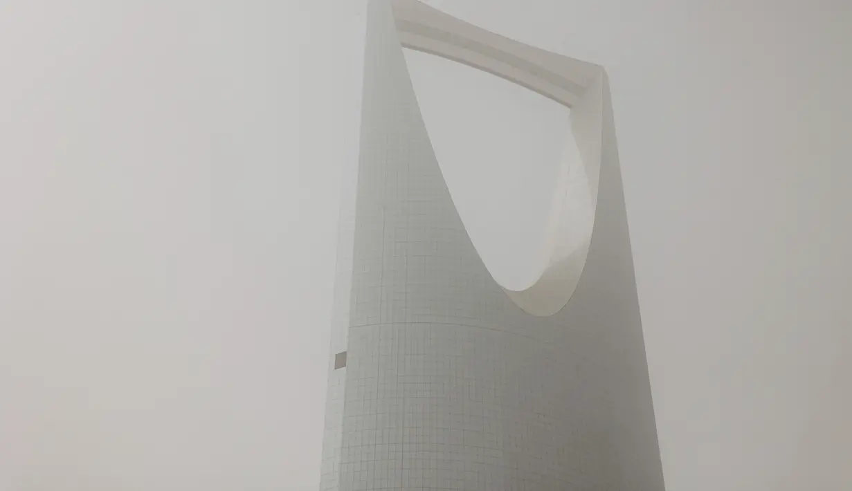 Pemandangan gedung pencakar langit Pusat Kerajaan selama badai debu berat di pusat ibu kota Arab Saudi, Riyadh (17/5/2022). Kabut abu-abu tebal membuat gedung-gedung ikonik Riyadh seperti Kingdom Center hampir tidak mungkin terlihat dari jarak lebih dari beberapa ratus meter. (AFP/Fayez Nureldine)