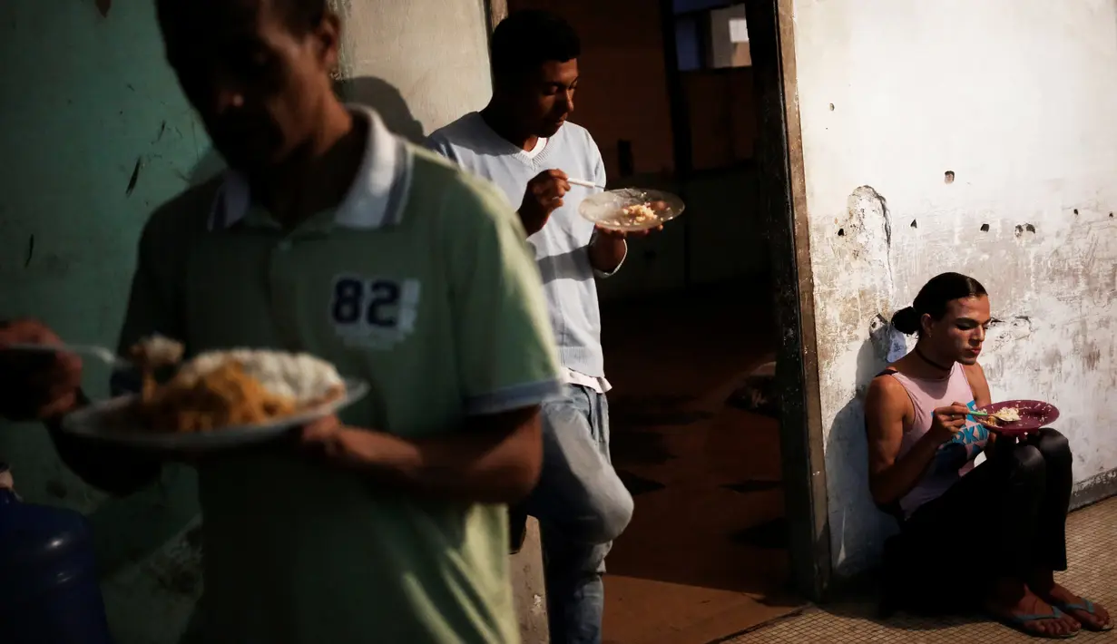 Patricia (kanan) bersama anggota LGBT lain makan bersama di gedung tua di Sao Paulo, Brasil (10/11). (Reuters/Nacho Doce)