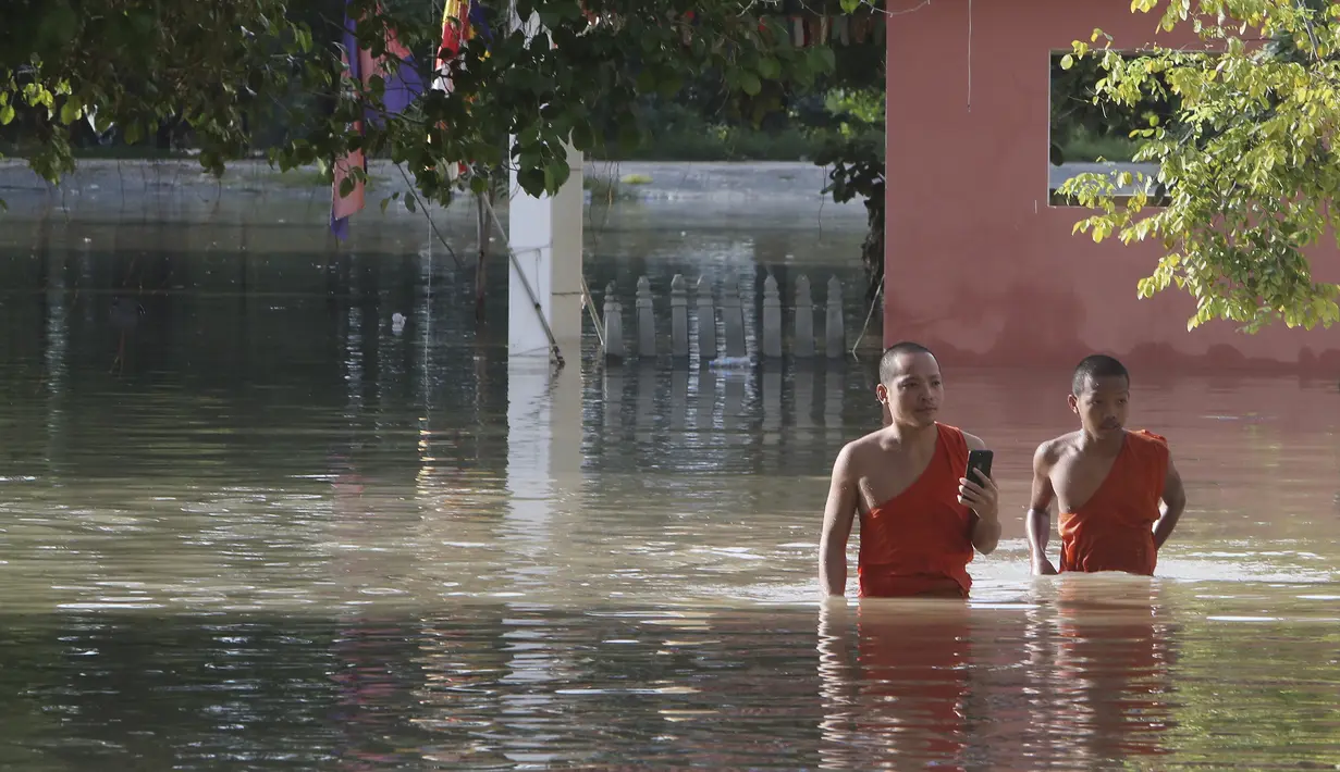 Biksu Buddha berjalan melewati pagoda yang banjir setelah hujan turun di Phnom Penh, Kamboja (14 /10/2020). Pejabat bencana Kamboja mengatakan Rabu bahwa lebih dari 10.000 orang telah dievakuasi ke tempat aman setelah badai tropis melanda yang menyebabkan banjir bandang.  (AP Photo/Heng Sinith)