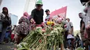 Pengunjung car free day menaburkan bunga di atas papan bertuliskan "Terima Kasih Pejuang Demokrasi" di Bundaran HI, Jakarta, Minggu (28/4/2019). Kegiatan tabur bunga tesebut sebagai bentuk belasungkawa atas meninggalnya petugas KPPS dalam Pemilu 2019. (Liputan6.com/Faizal Fanani)