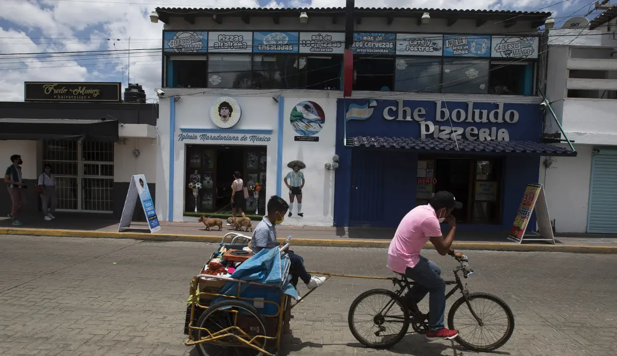 Gereja Maradona berdiri di sebelah kedai pizza di San Andres Cholula, negara bagian Puebla, Meksiko, Minggu (18/7/2021). Sang pembuat gereja mengatakan Gereja Diego Maradona jadi tempat untuk berbicara semua hal yang berkaitan dengan sepak bola. (AP Photo/Marco Ugarte)