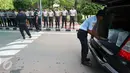 Pamdal DPR mengecek kendaraan sementara sejumlah aparat kepolisian berjaga di pintu masuk Gedung MPR/DPR RI,  Senayan, Jakarta, Jumat (31/3). Polda Metro Jaya memberikan pengamanan ketat di sekitar DPR terkait aksi 31 Maret. (Liputan6.com/Johan Tallo)