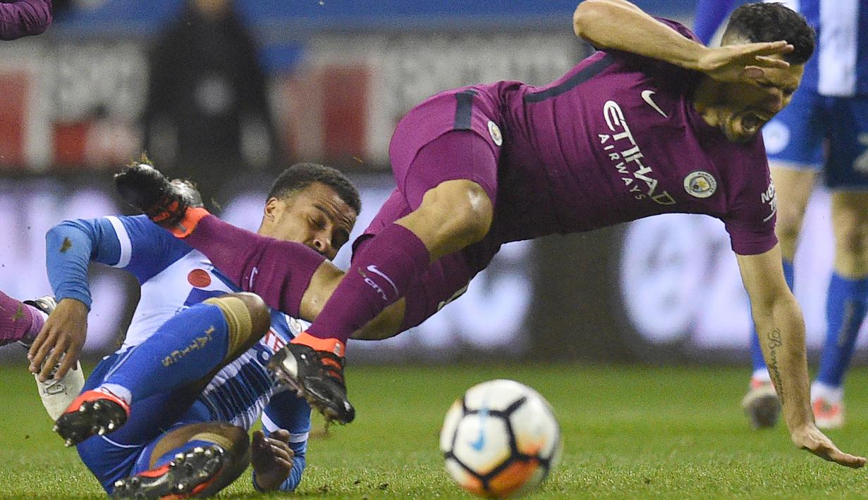 Pemain Wigan Athletic,  Nathan Byrne menjegal penyerang Manchester City, Sergio Aguero (kanan) pada laga babak kelima Piala FA di DW Stadium, Wigan, (19/2/2018). Manchester City kalah 0-1. (AFP/Oli Scarff)