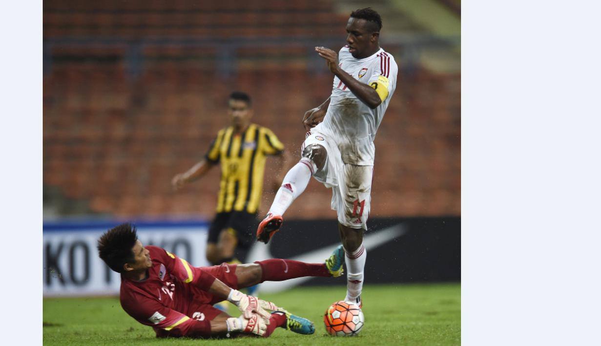 Kiper Malaysia, Mohd Izham Tarmizi, berusaha menahan bola tendangan pemain UEA, Ahmed Khalil, dalam Kualifikasi Piala Dunia 2018 di Stadion Shah Alam, Malaysia, (17/11/2015). Malaysia kalah 1-2 dari UEA. (AFP Photo/Manan Vatsyayana)