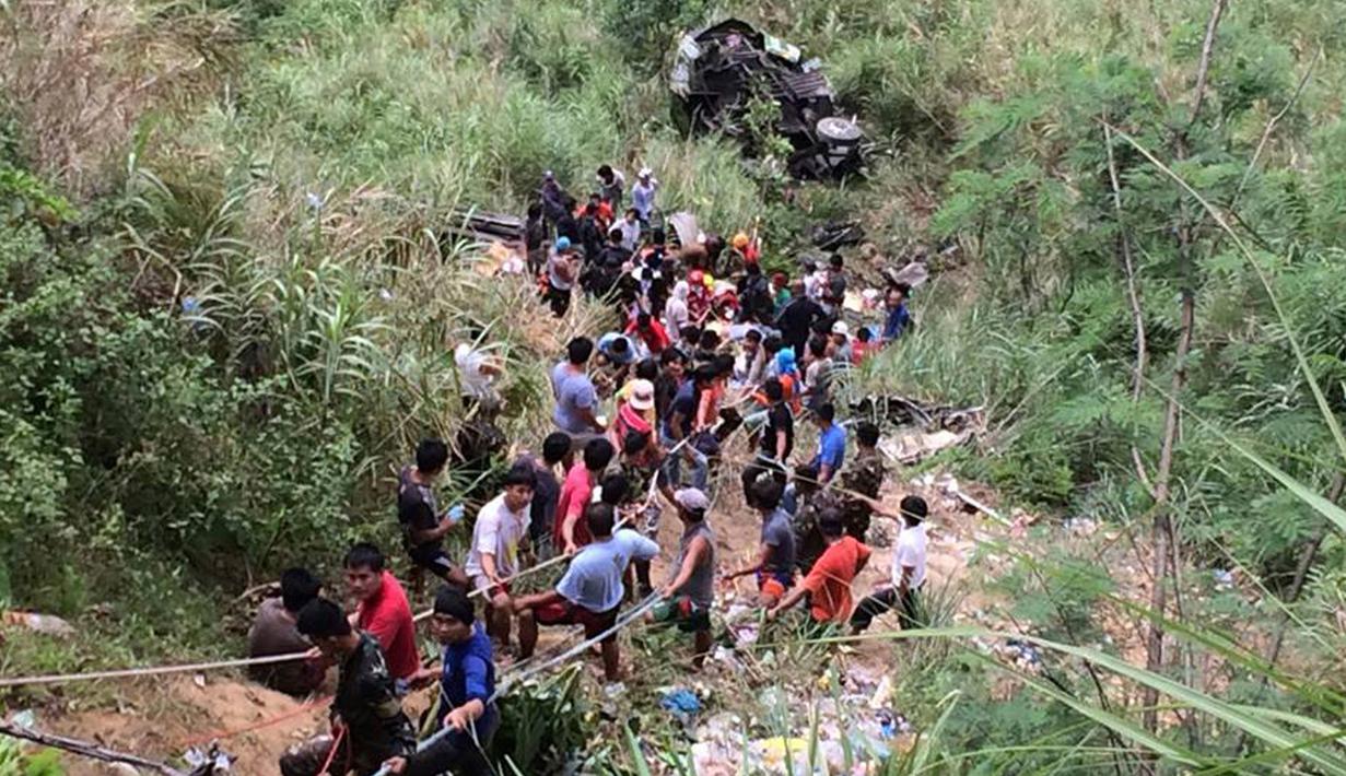 Relawan membantu evakuasi para penumpang bus yang terjun ke jurang di Kota Carranglan, Provinsi Nueva Ecija di Filipina Utara, Selasa (18/4). Setidaknya 26 orang tewas dan 21 lainnya mengalami luka-luka. (Philippine Red Cross Nueva Vizcaya chapter via AP)