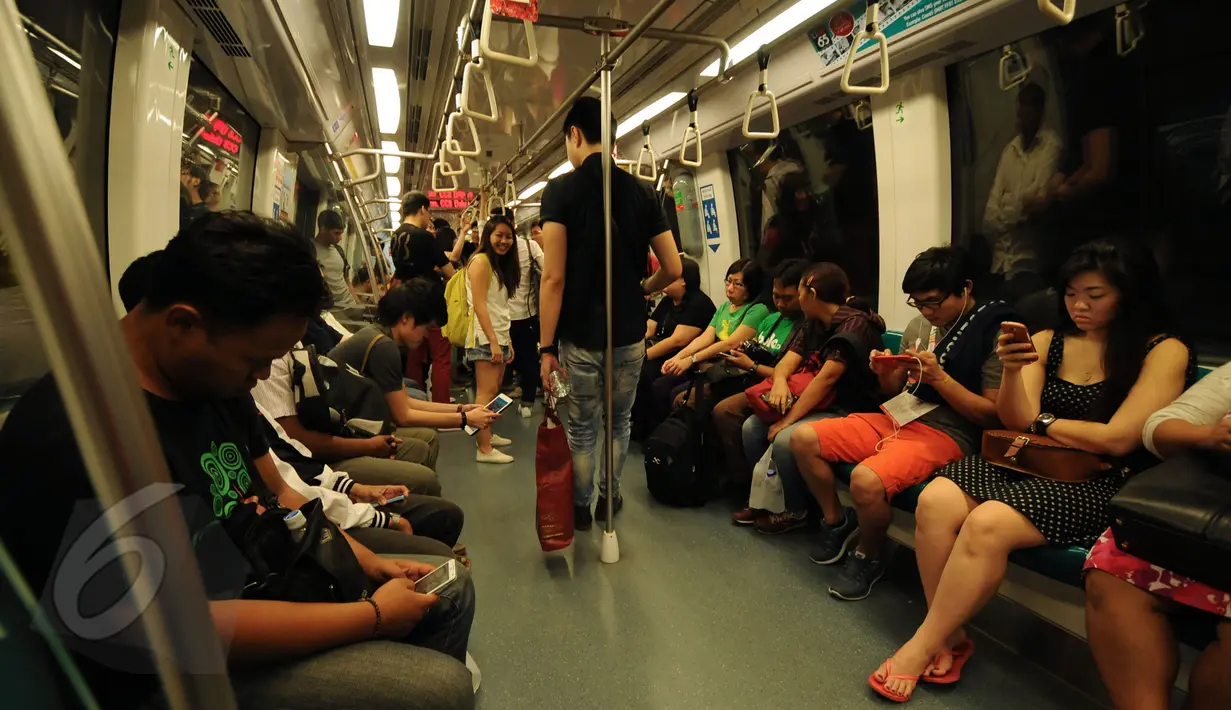 Sejumlah pengguna moda transportasi di Singapura terlihat berada di dalam kereta MRT, Minggu (31/5/2015). MRT menjadi sistem angkutan cepat yang membentuk tulang punggung dari sistem kereta api di Singapura. (Liputan6.com/Helmi Fithriansyah)